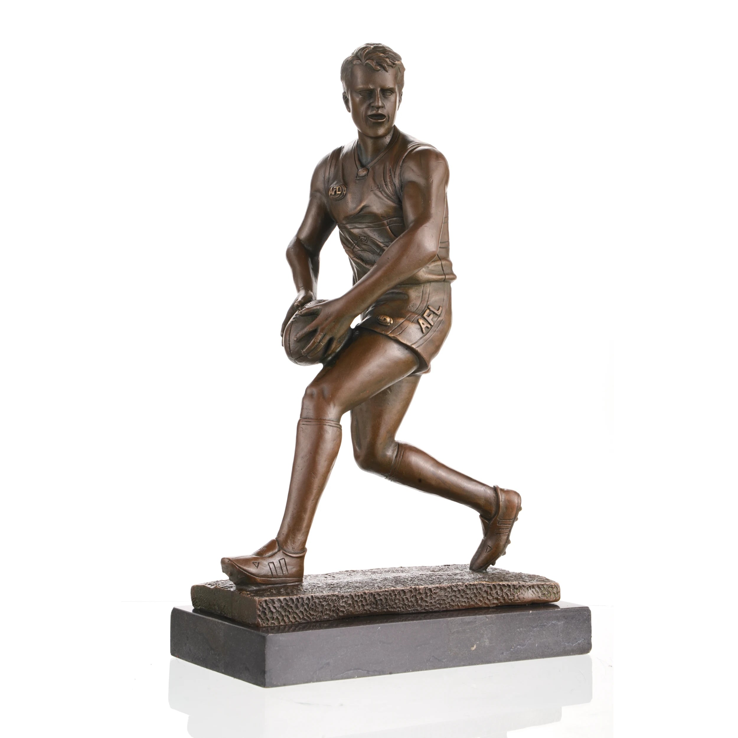 AFL football player bronze statue mid-run with oval ball, hyper-realistic Australian Rules Football statue on black marble base, loss wax casting sports art for trophies.