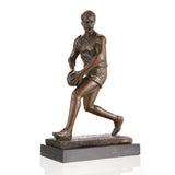 AFL football player bronze statue mid-run with oval ball, hyper-realistic Australian Rules Football statue on black marble base, loss wax casting sports art for trophies.