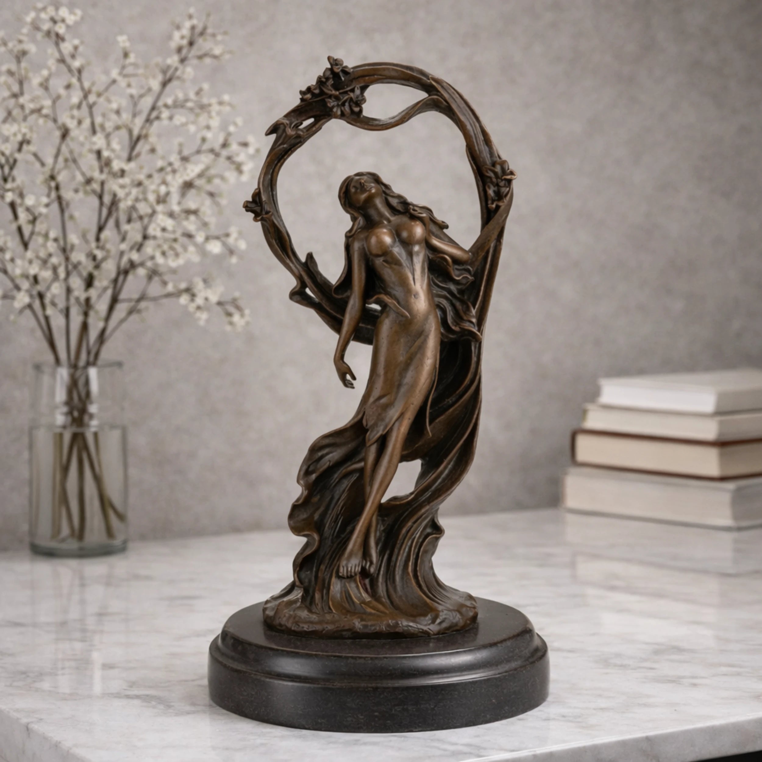 Art Nouveau bronze woman sculpture holding an orb, ethereal maiden statue with billowing gown and floral arch on black marble base, loss wax casting fine art.