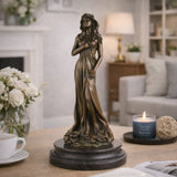 Elegant Art Nouveau bronze floral maiden statue with flowing gown and flowers, slender female figure on tiered circular dark marble base, loss wax casting fine art.