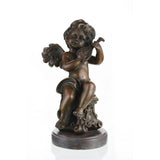 Charming bronze cherub sculpture playing mandolin, seated putto with lute on scroll-carved pedestal, loss wax casting musical art on dark marble base.