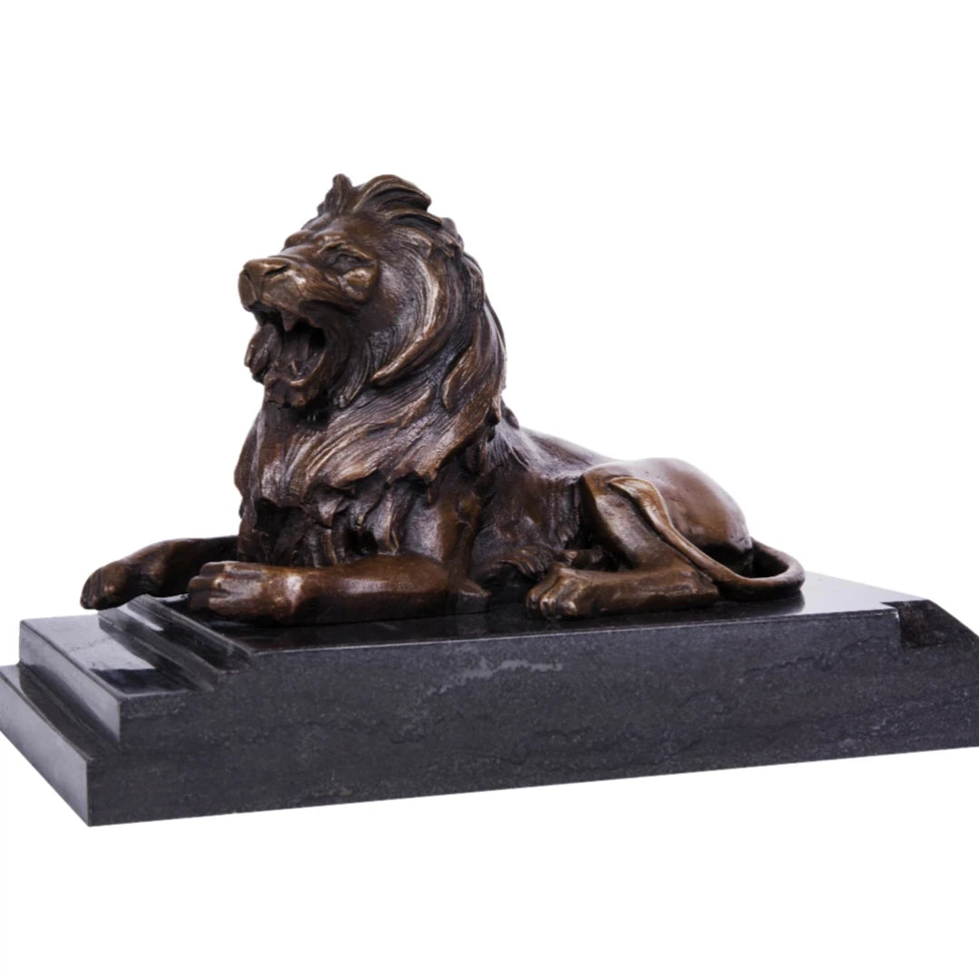 This powerful bronze lion sculpture, crafted using the lost-wax casting method, depicts the animal in a reclining pose with its mouth open in a fierce roar. The rich, aged bronze patina highlights the lion’s taut musculature and detailed mane, conveying raw strength and authority. Its raised head and alert posture suggest dominance and vigilance.