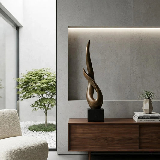 Minimalist abstract bronze sculpture of intertwined fluid forms, modern flame silhouette statue on square black marble base, loss wax casting symbolic art.