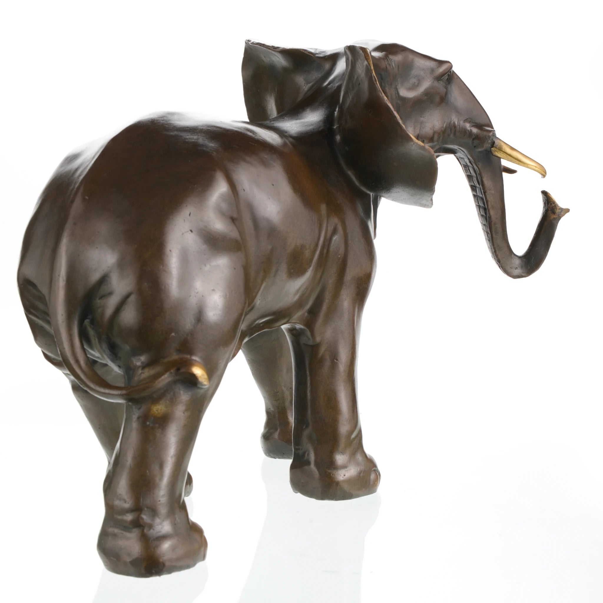 a stately bronze sculpture of an African elephant, crafted using the lost-wax casting method. The piece captures the elephant in a steady, forward-moving stance, conveying a sense of calm strength and quiet authority.
