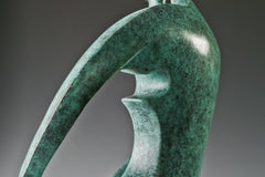 Close-up of the curved bronze arms forming a heart-like shape around the couple