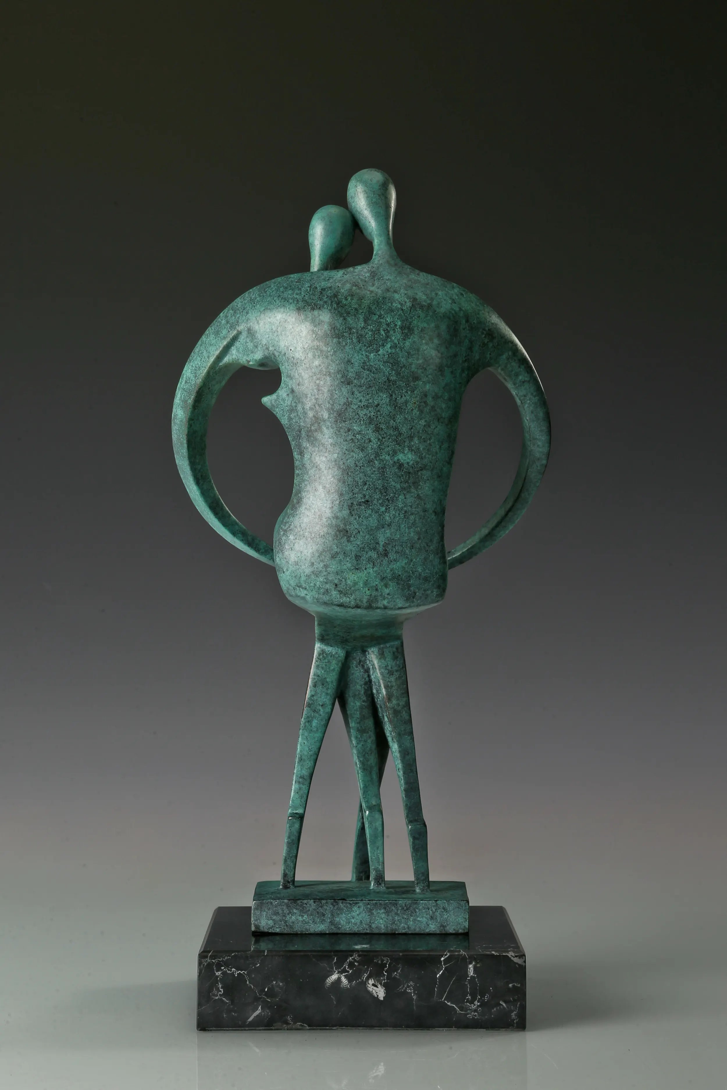 Back view of abstract couple bronze sculpture showing its rounded silhouette and green patina