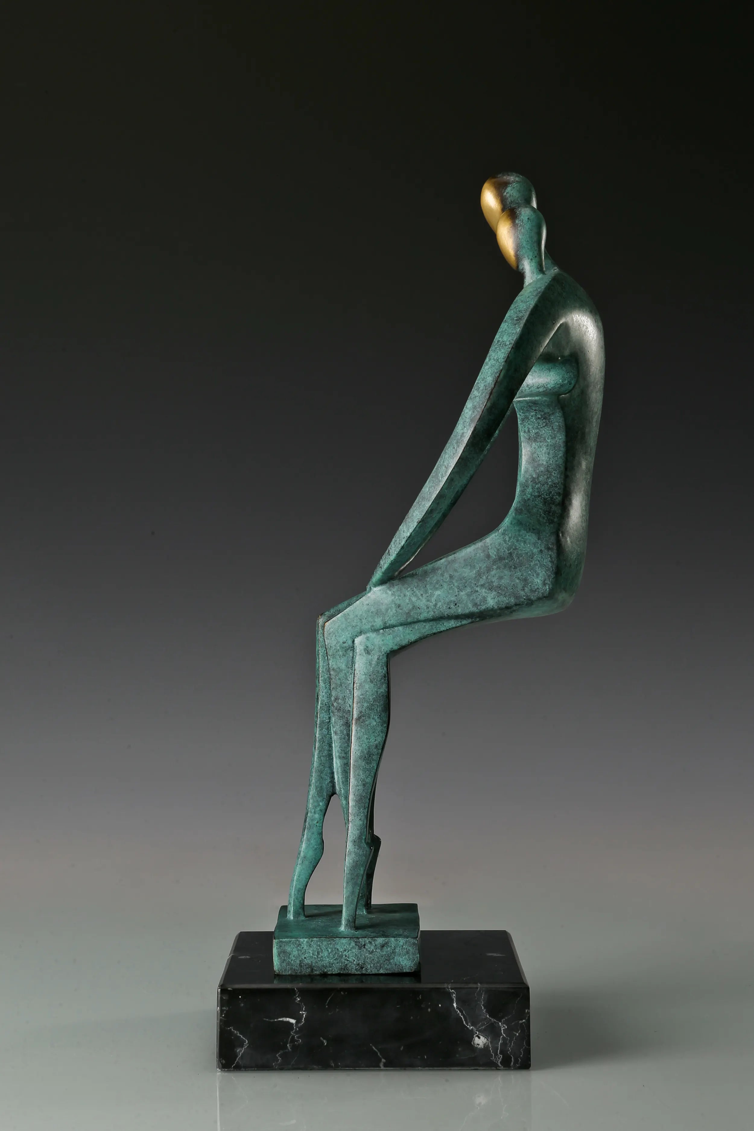 Side profile of two abstract bronze figures leaning toward each other
