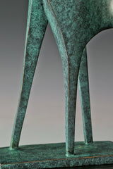 Detail of elongated bronze legs and angular lower forms with a green patina finish