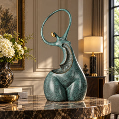 Abstract dancing woman bronze sculpture displayed on a stone pedestal in a modern interior
