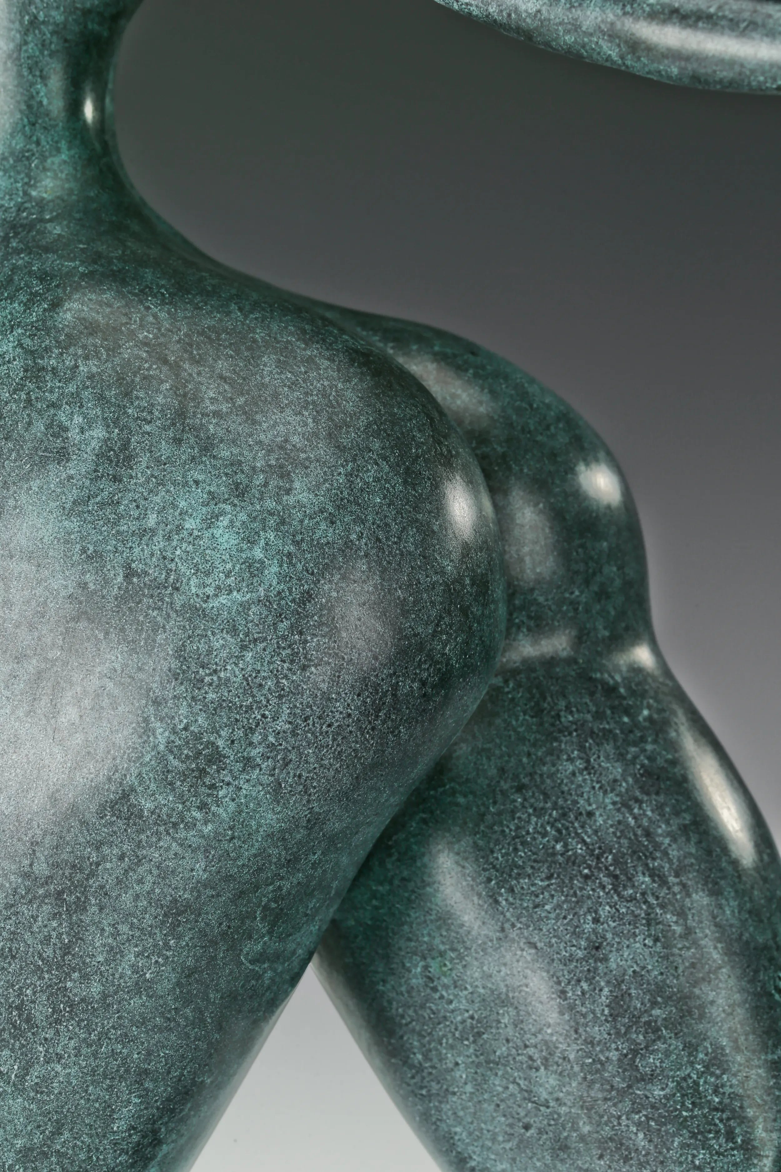 Close-up of the rounded hip on the abstract dancing female bronze sculpture