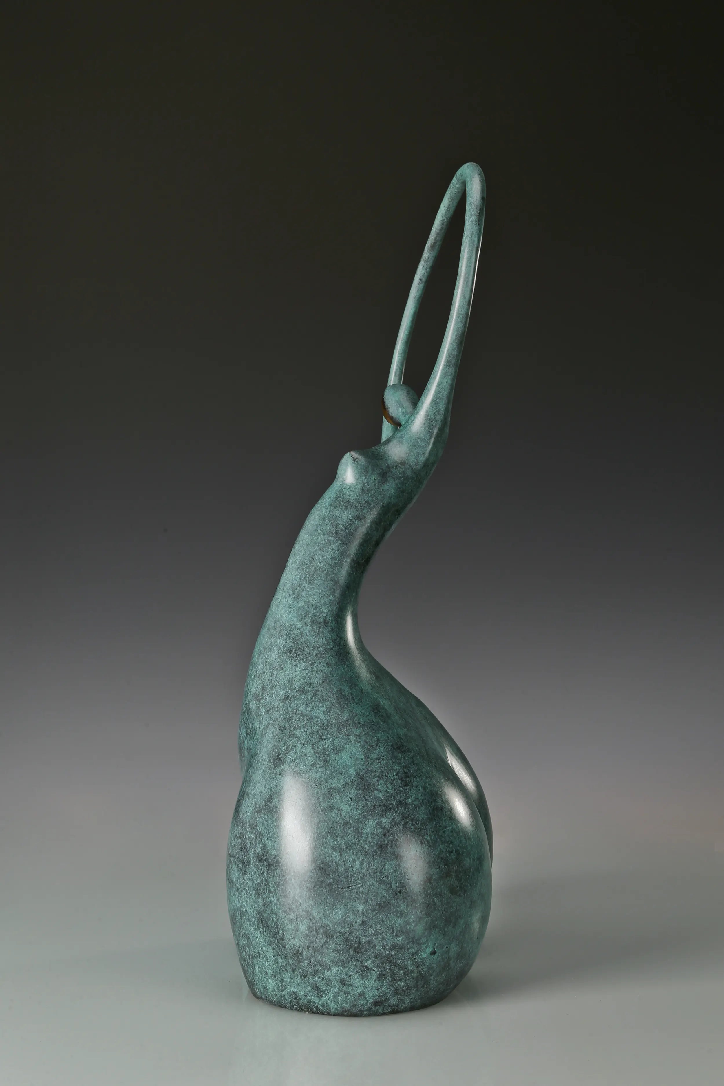 Side profile of abstract bronze dancer showing the tall circular upper form