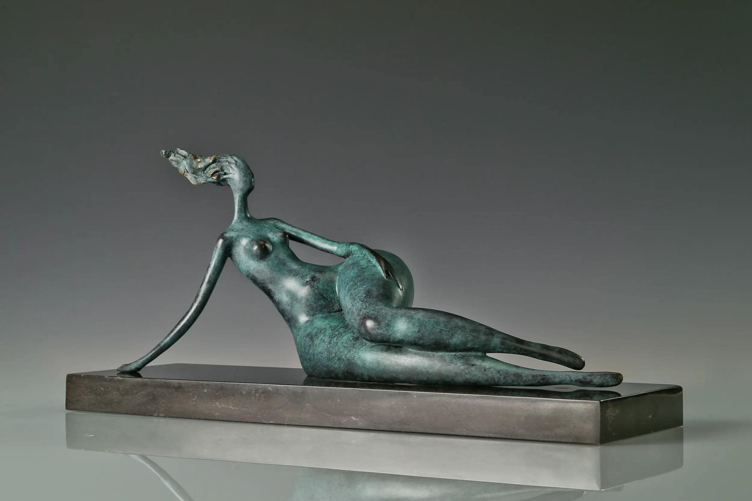 Angled view of abstract reclining woman sculpture showing her relaxed pose