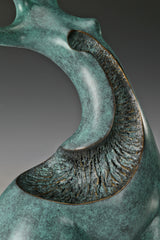 Close-up of textured openwork section and curved bronze surface with green patina