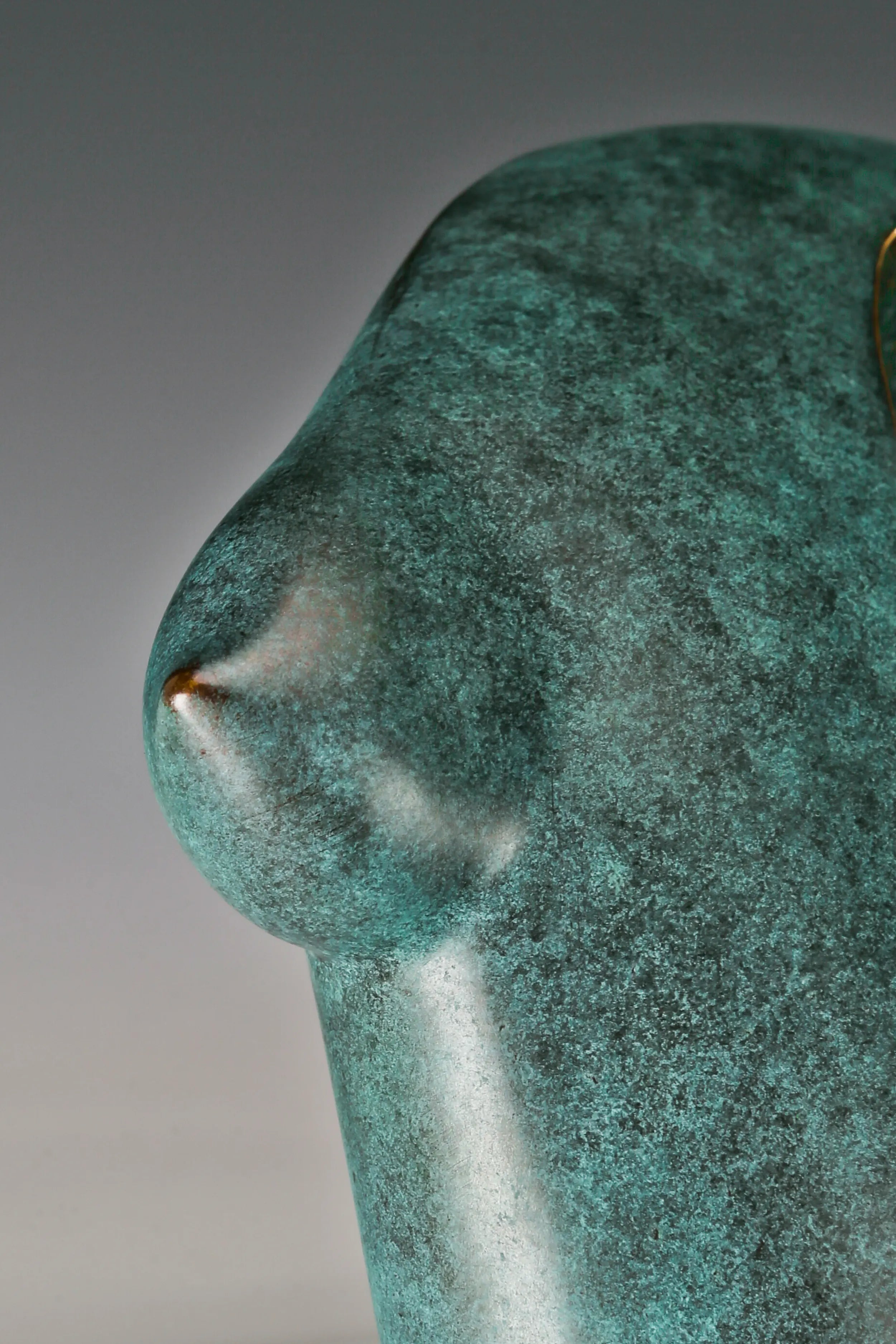 Close-up of smooth green patina and sculpted female torso contours