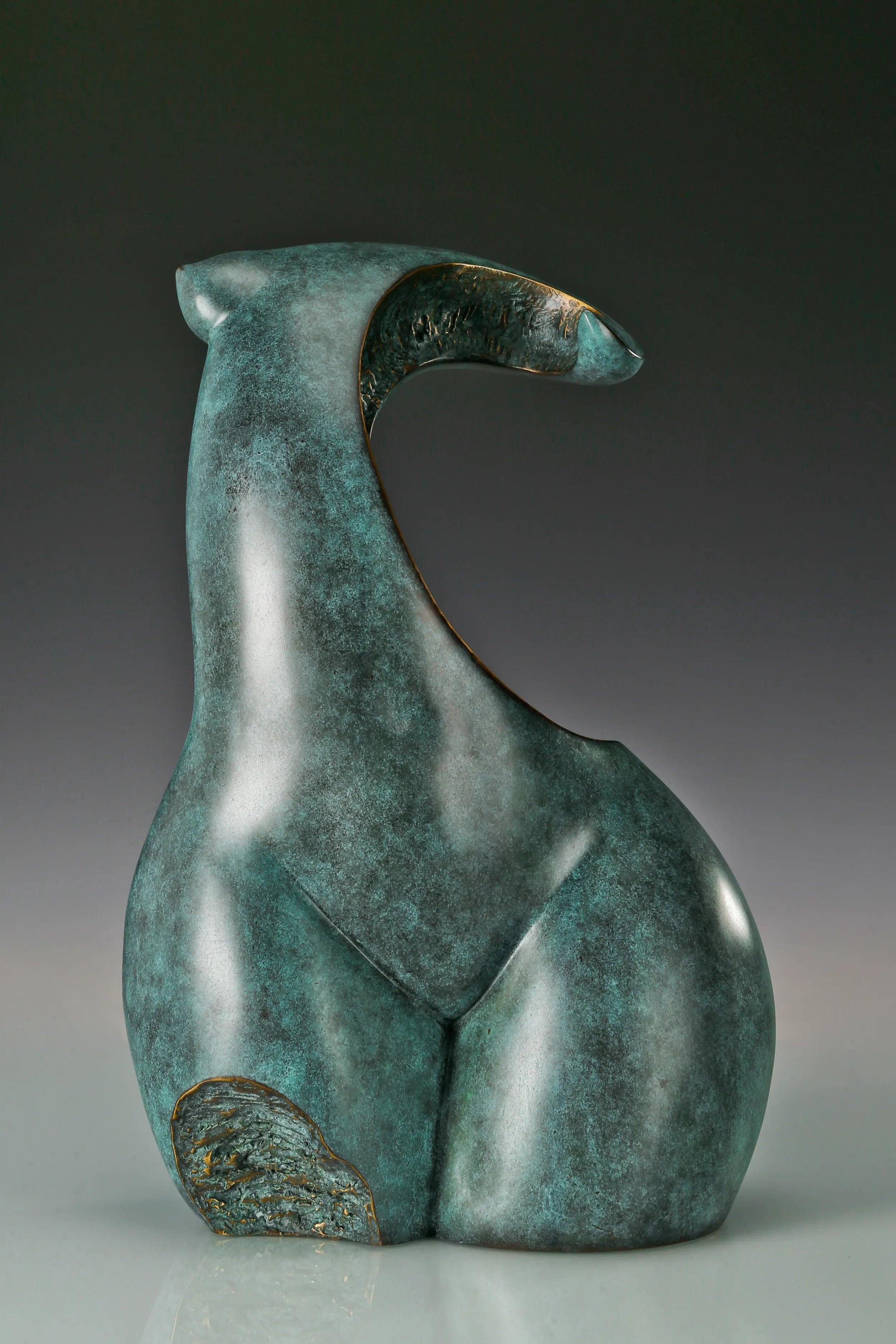 Front view of modern abstract female torso sculpture with textured gold accents
