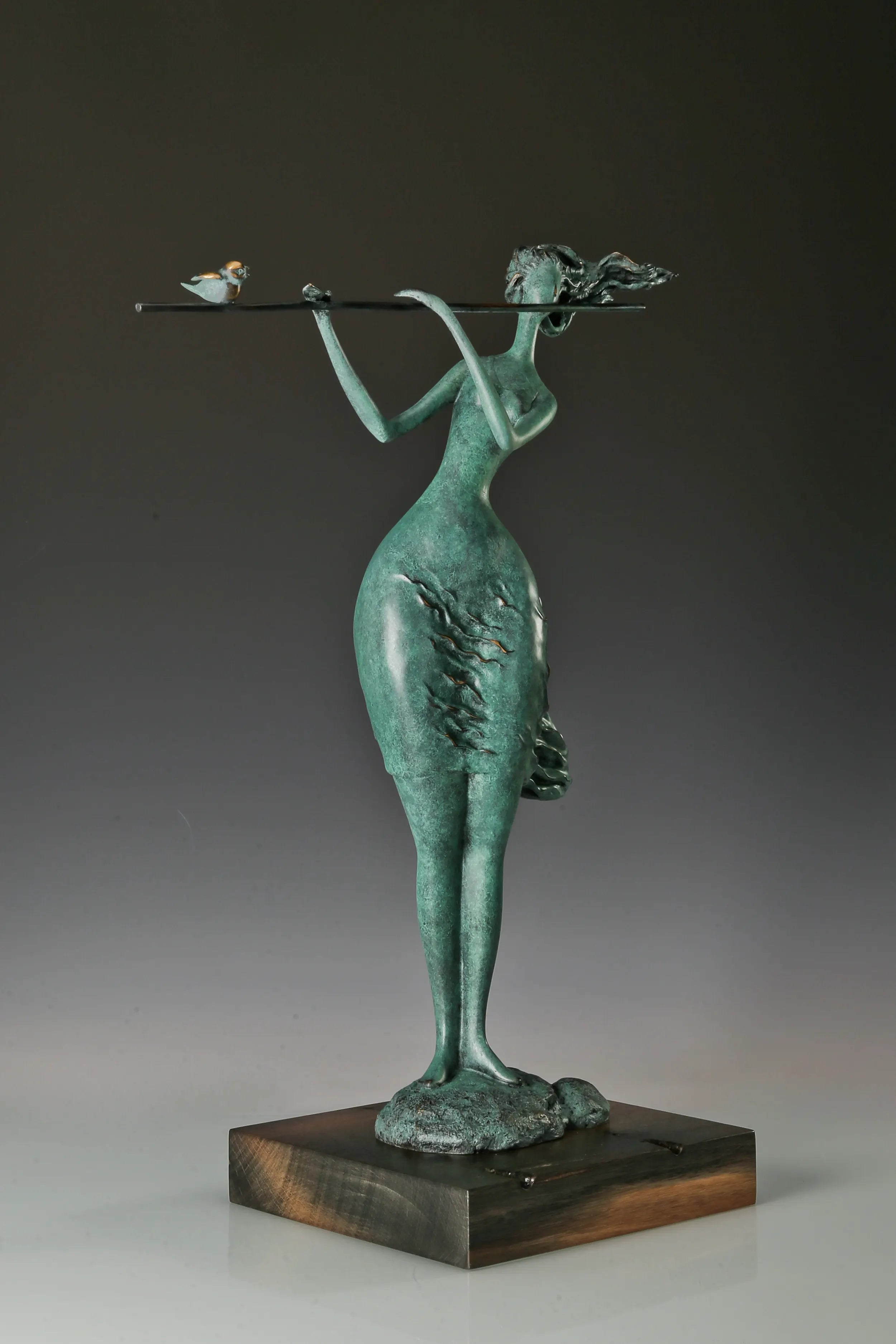 Three-quarter view of abstract flute player bronze sculpture with a bird on the flute