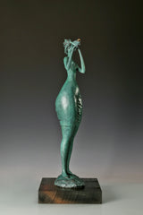 Left side view of an elongated female musician sculpture with green bronze patina