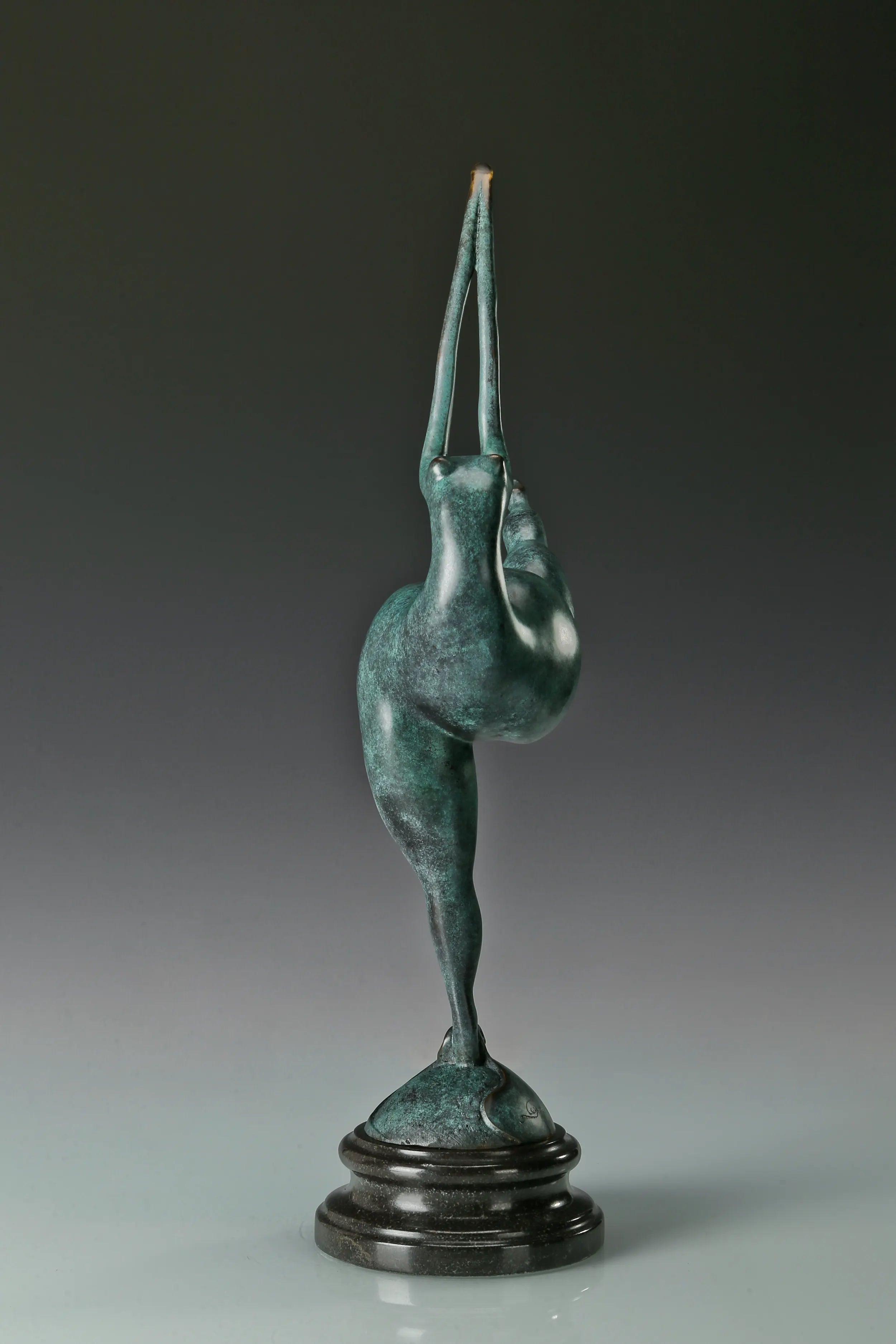 Side profile of abstract gymnast statue with elongated raised arms