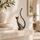 Abstract sitting cat bronze sculpture with curved tail displayed in a modern interior