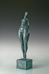 Front view of abstract standing female bronze figure with elongated proportions and green patina