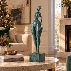 Abstract standing woman bronze sculpture with green patina displayed on a modern living room console