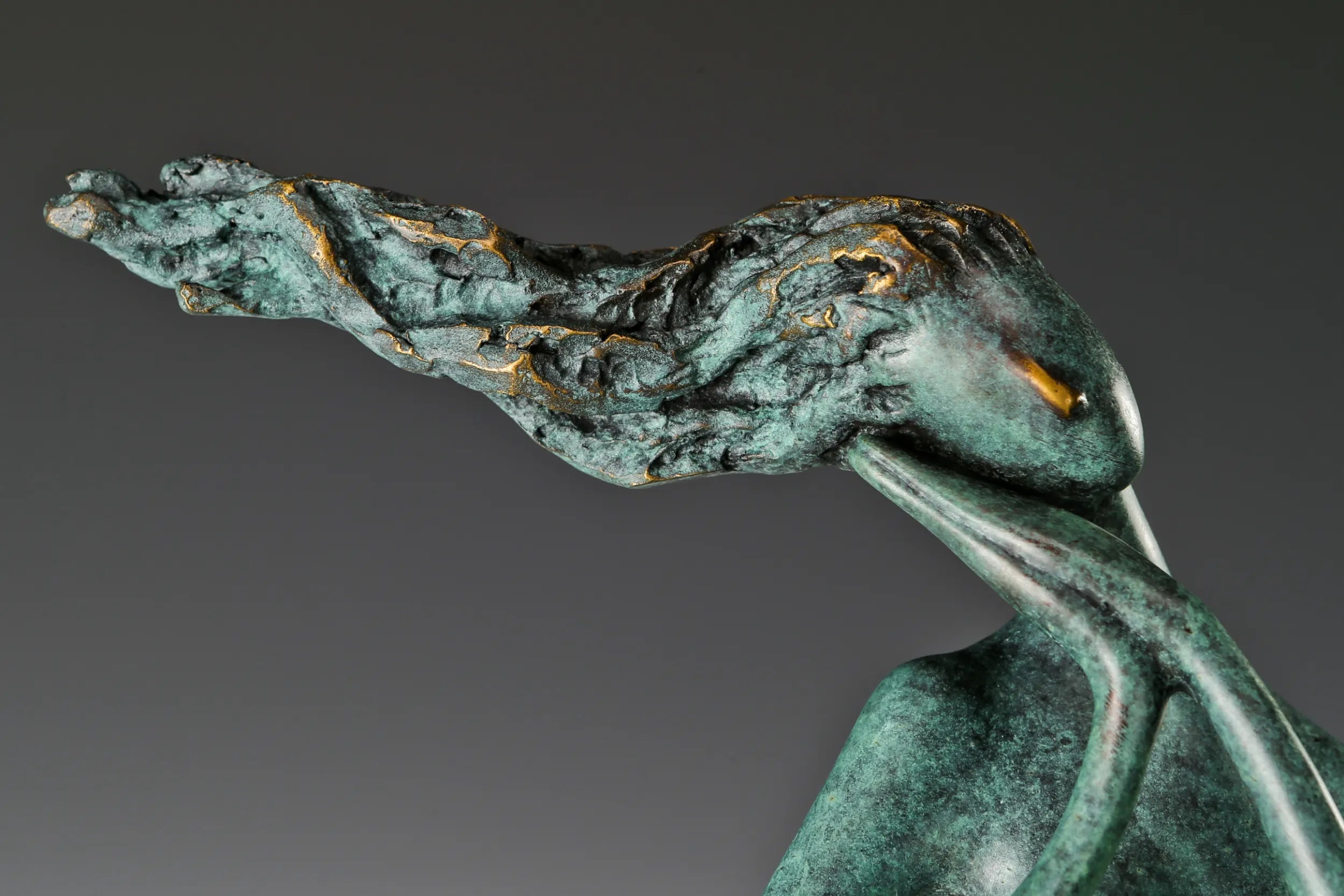 Close-up of the abstract woman's windswept hair and face with textured green bronze patina