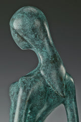 Side detail of the tilted head, neck, and shoulders of the bronze woman sculpture