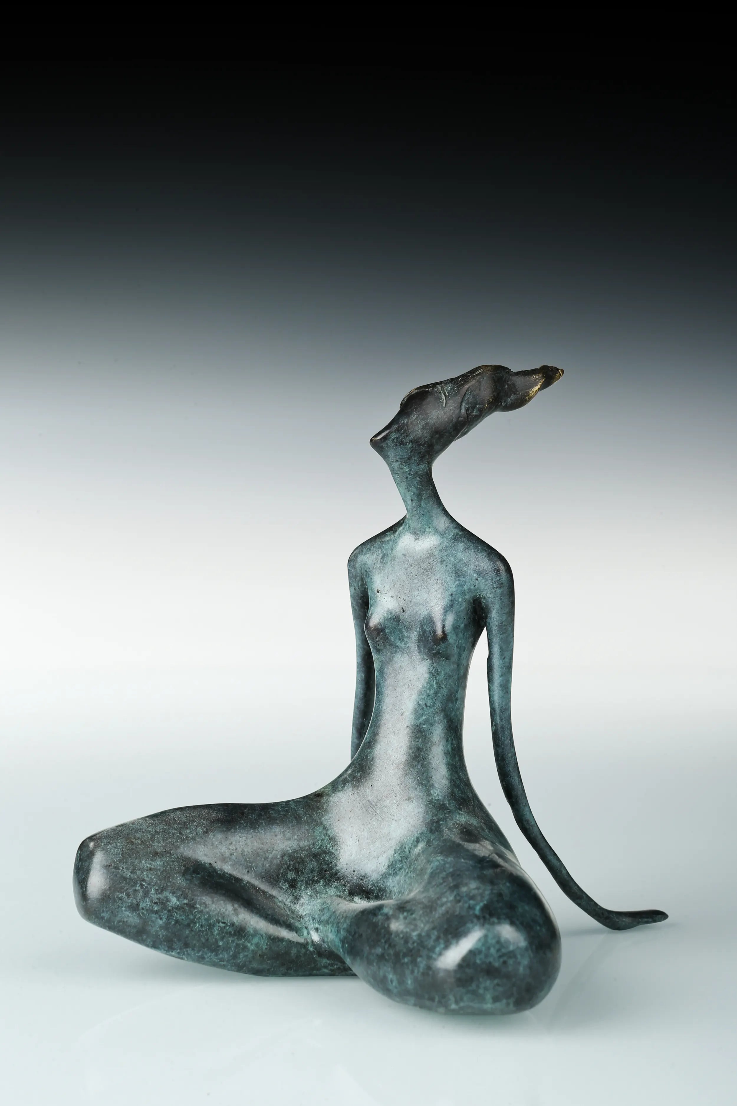 Angled view of bronze yoga woman sculpture showing its curved seated posture