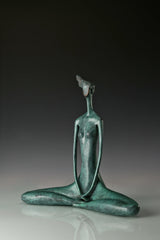 Front angled view of a seated female yoga sculpture with hands resting in her lap