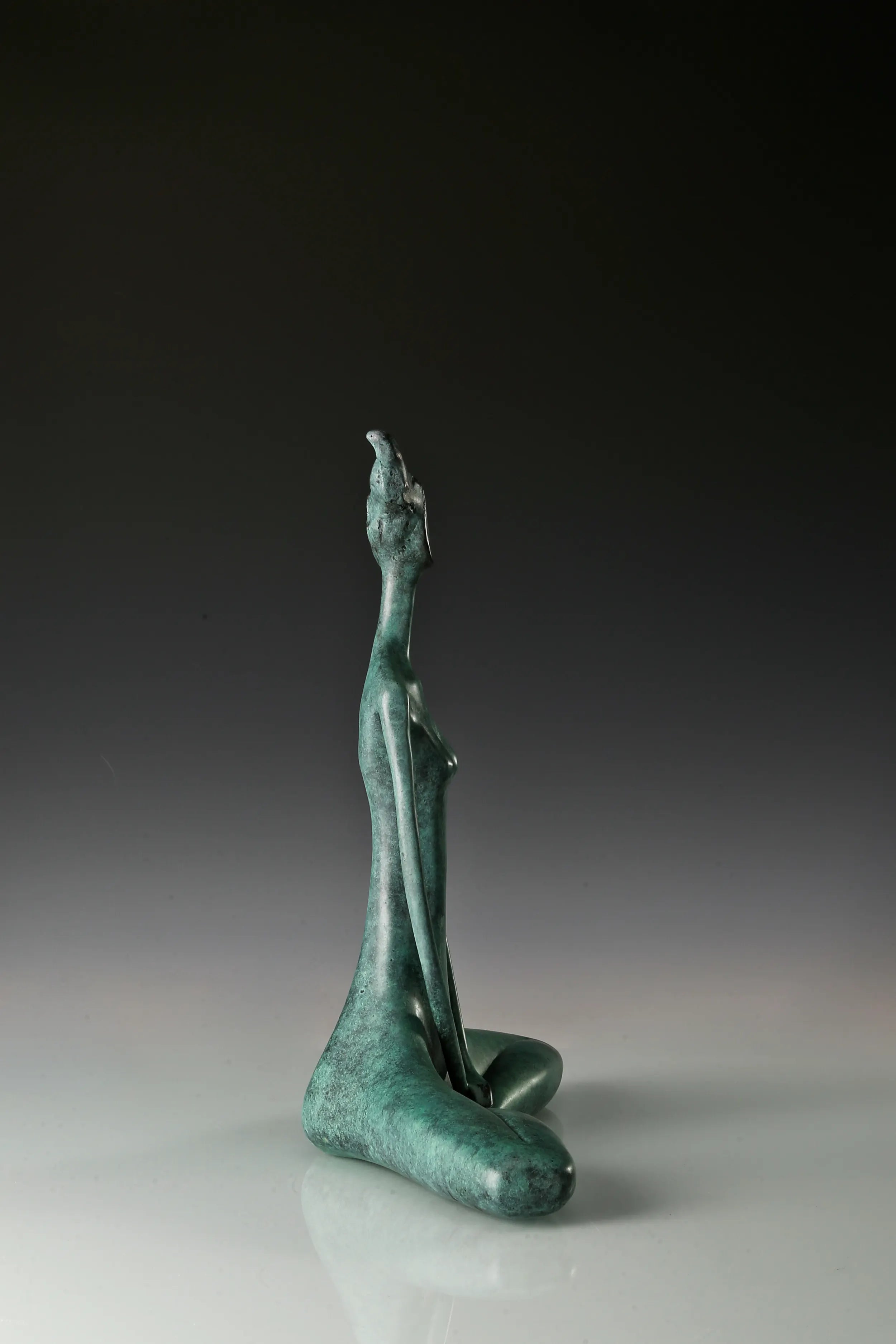 Opposite side view of minimalist seated woman bronze sculpture