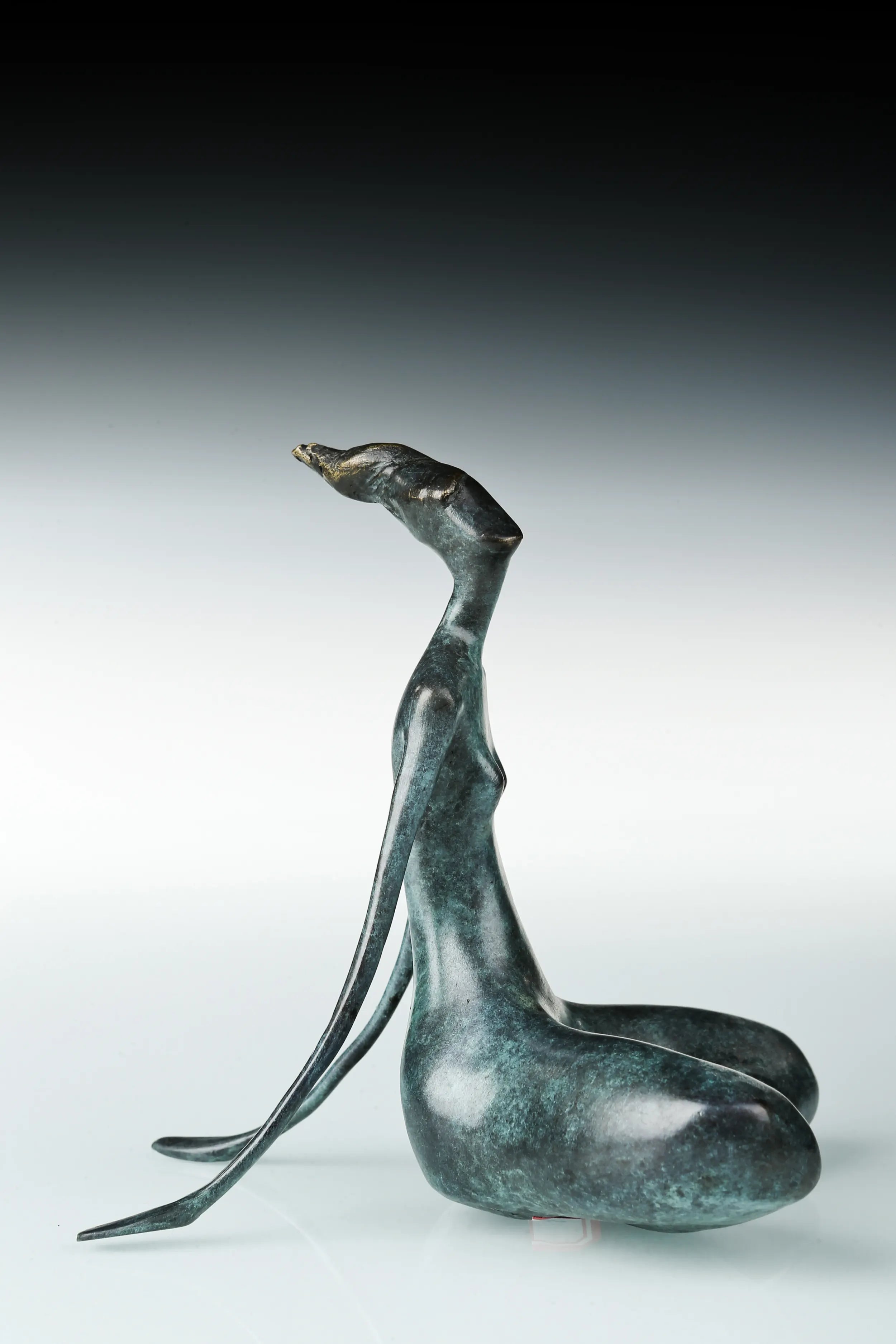 Side profile of seated yoga woman bronze sculpture with a long neck