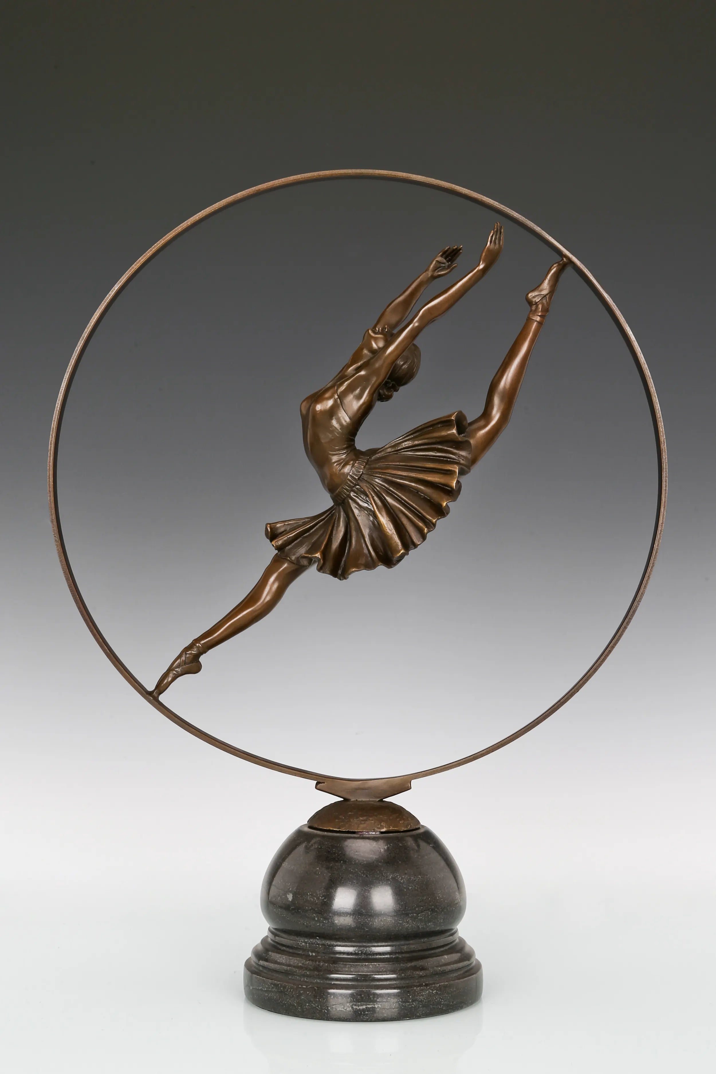 Angled view of bronze ballerina sculpture featuring a flowing tutu and circular frame