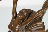 Close-up of the bronze ballerina figure with gracefully extended arms