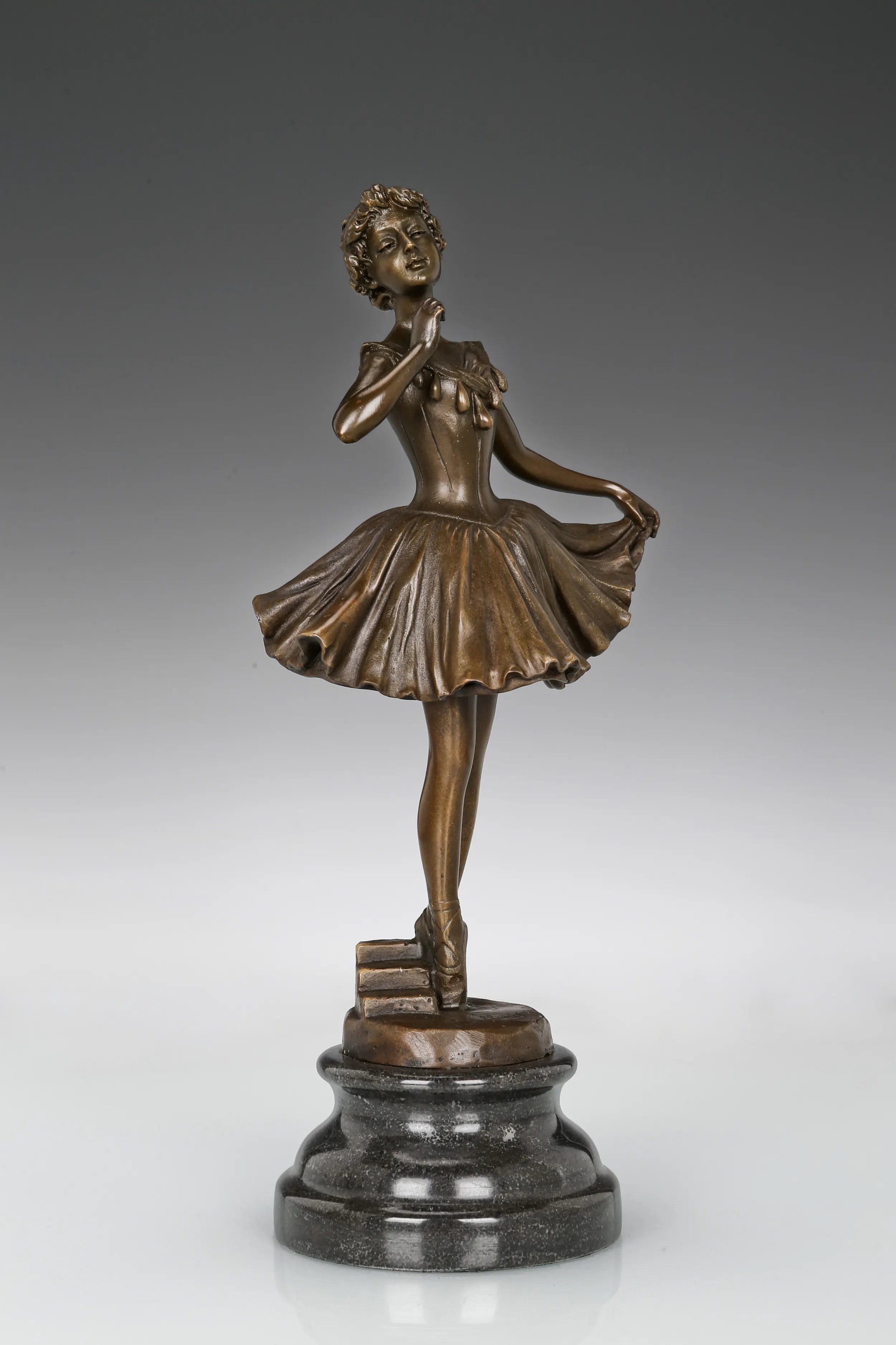 Three-quarter view of ballerina bronze sculpture gently lifting her skirt