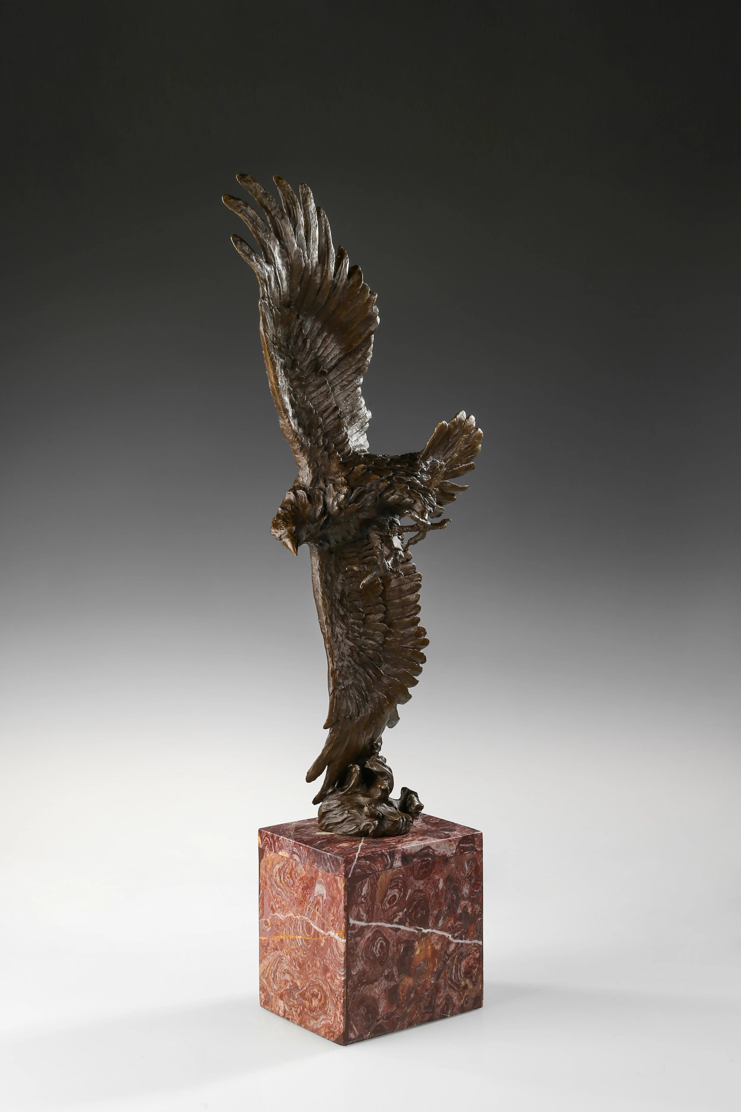 Mythic bronze eagle sculpture diving over waves. A powerful statement piece symbolizing strength, freedom, and mastery of the elements.