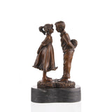 Rear view of a handcrafted bronze boy and girl sculpture with detailed clothing and bouquet.