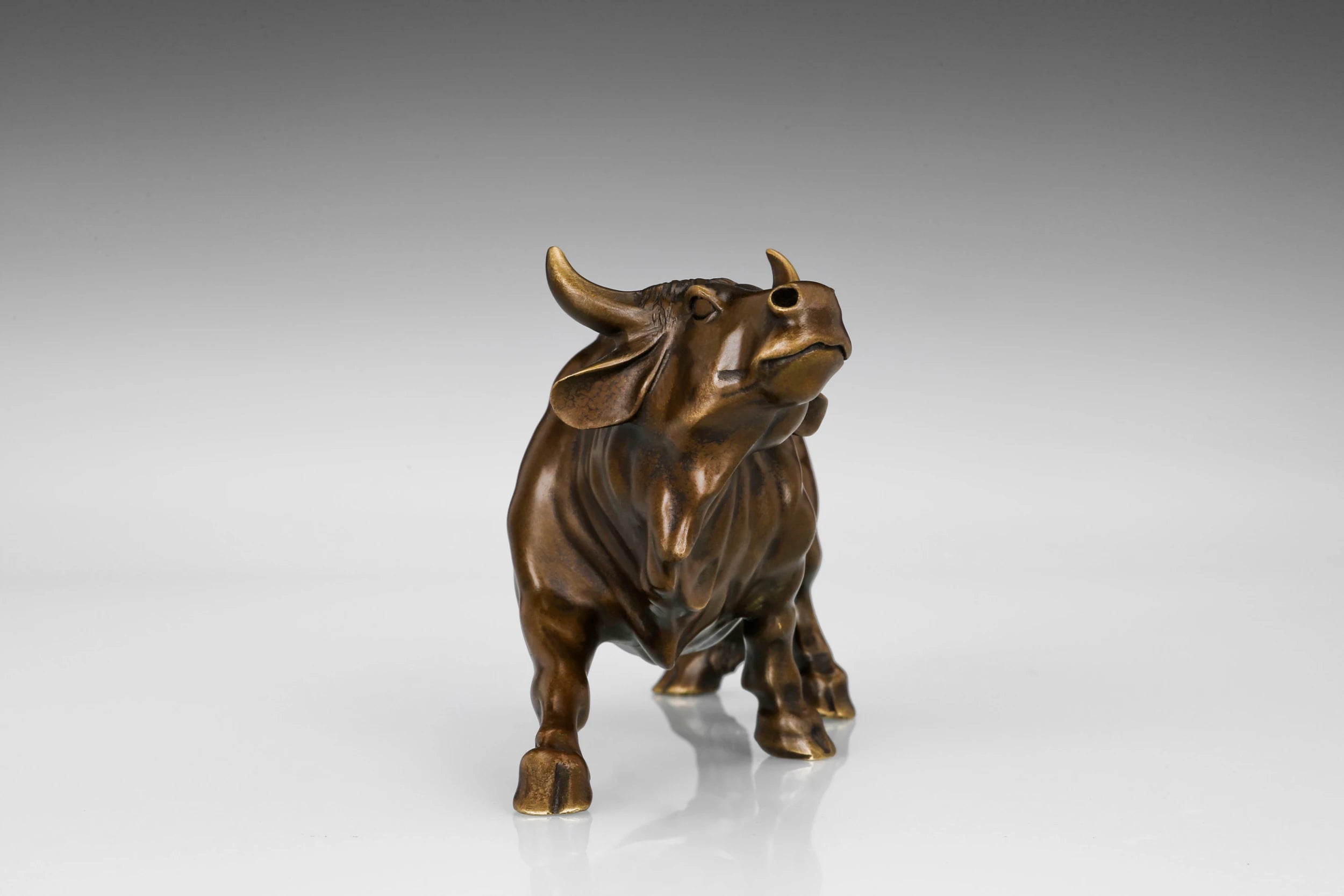 Close-up of the bronze bull's head with polished golden horns and expressive facial details.