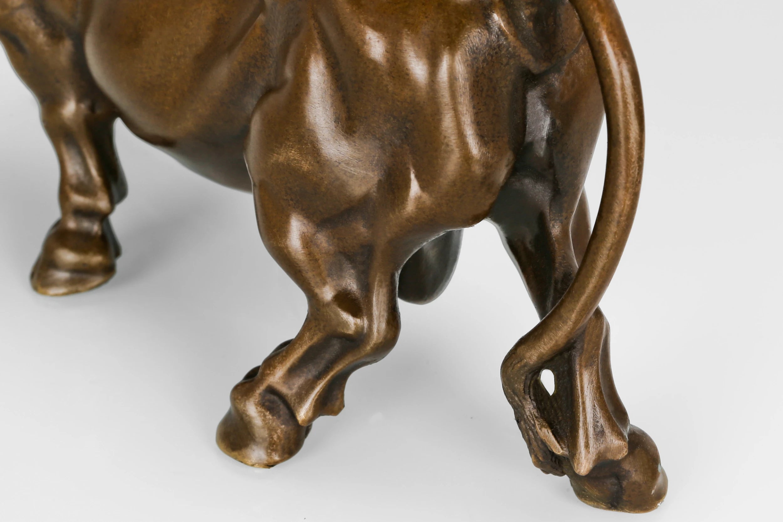 Detailed view of the handcrafted bronze bull sculpture highlighting realistic musculature and warm bronze patina.