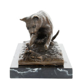 Close-up of bronze cat paw reaching toward a butterfly in a playful nature-inspired scene
