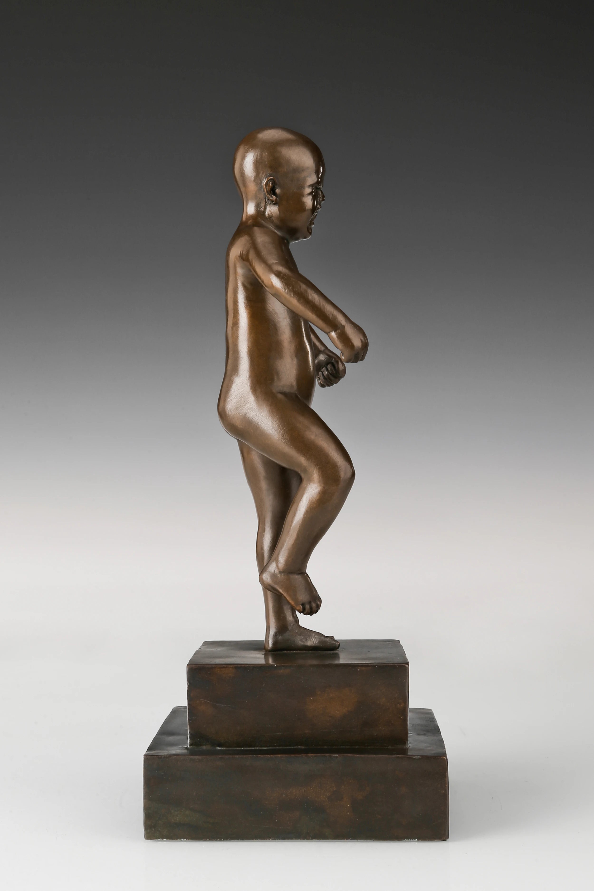Right side view of expressive bronze child sculpture with dynamic body posture