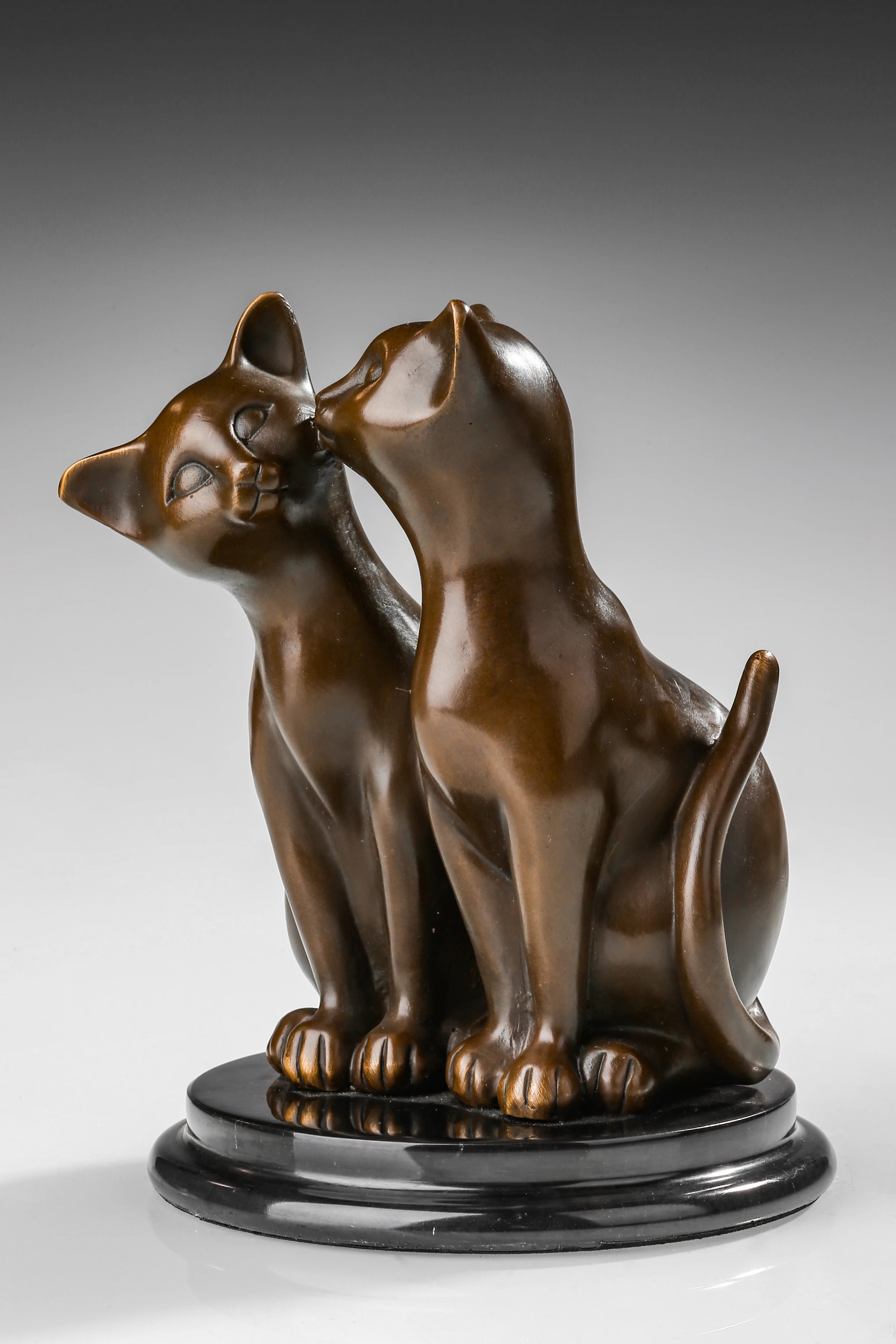 Angled view of bronze kissing cats sculpture showing their affectionate pose and smooth contours