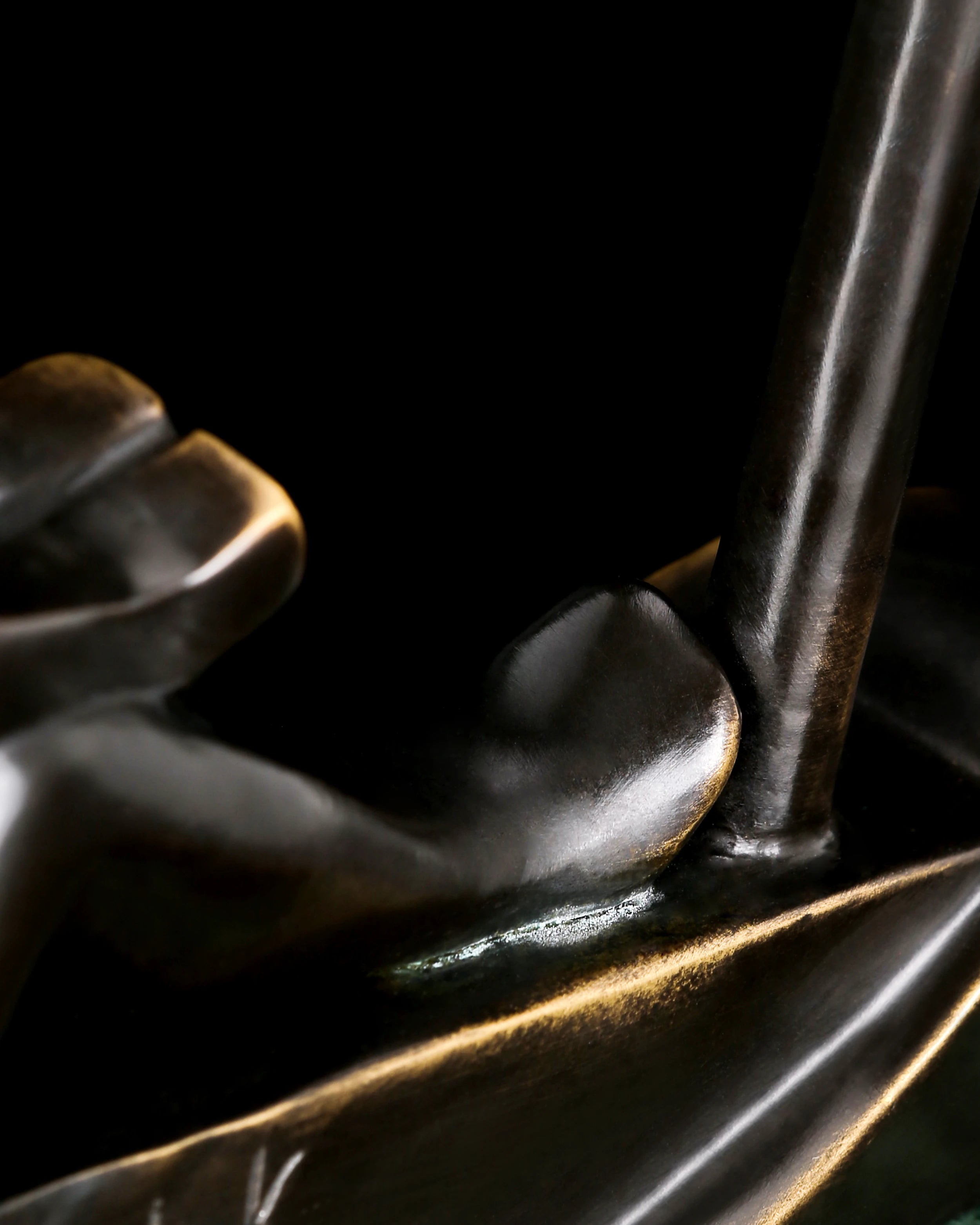 Detail of tall mast on abstract bronze sailing sculpture with minimalist nautical styling