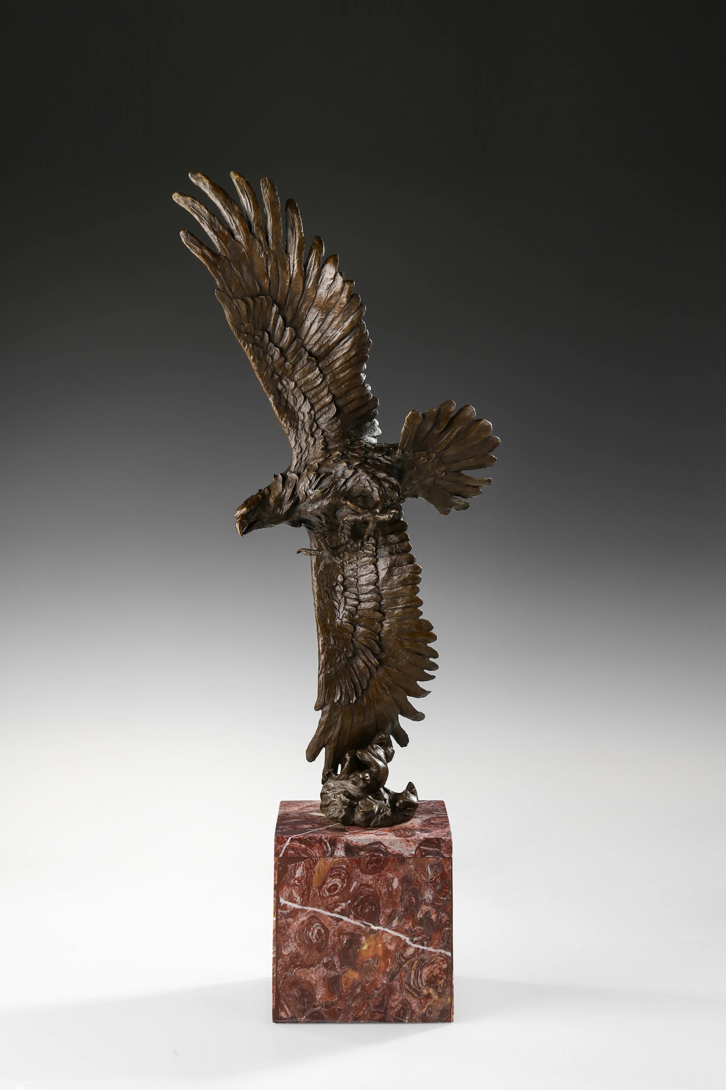 Bronze eagle sculpture over ocean waves with detailed feathers and marble base. Unique wildlife statue for home decor and collectors.
