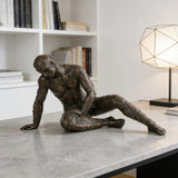 Contemporary bronze sculpture crouching male figure with chessboard symbols pattern, conceptual human form statue mid-movement, loss wax casting avant-garde art.