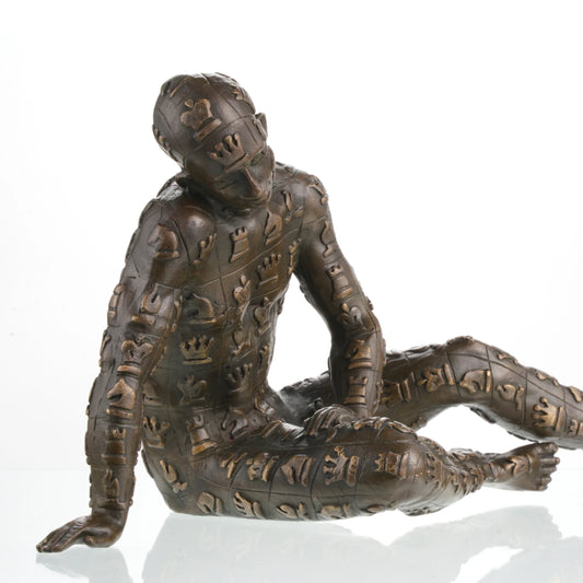Contemporary bronze sculpture crouching male figure with chessboard symbols pattern, conceptual human form statue mid-movement, loss wax casting avant-garde art.