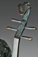 Close-up of the Chinese pipa's long neck, tuning pegs, and bronze surface details