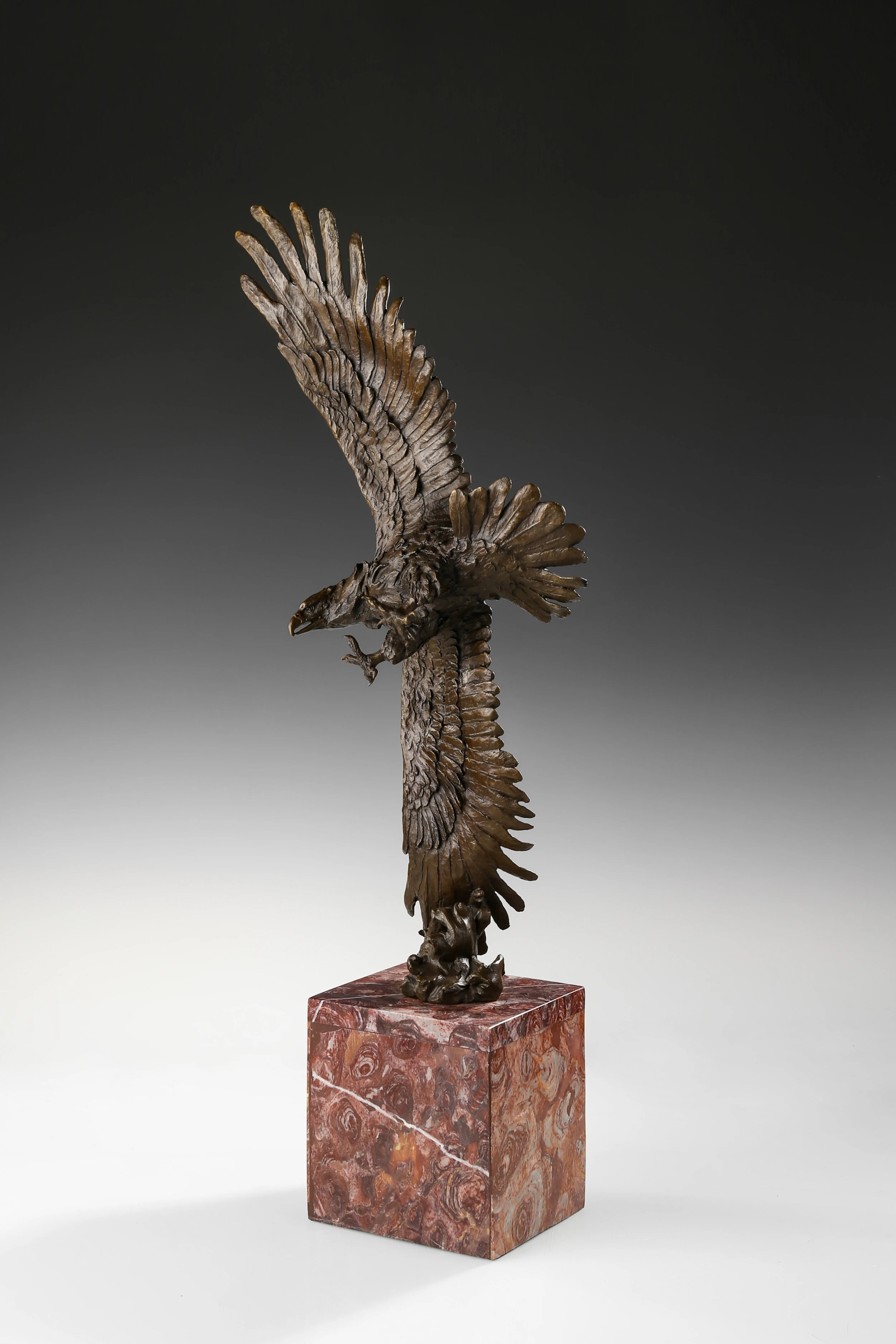 Mythic bronze eagle sculpture diving over waves. A powerful statement piece symbolizing strength, freedom, and mastery of the elements.