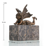 Whimsical bronze reclining fairy sculpture with butterfly wings on gold-veined marble base, magical fantasy art for bedroom decor.