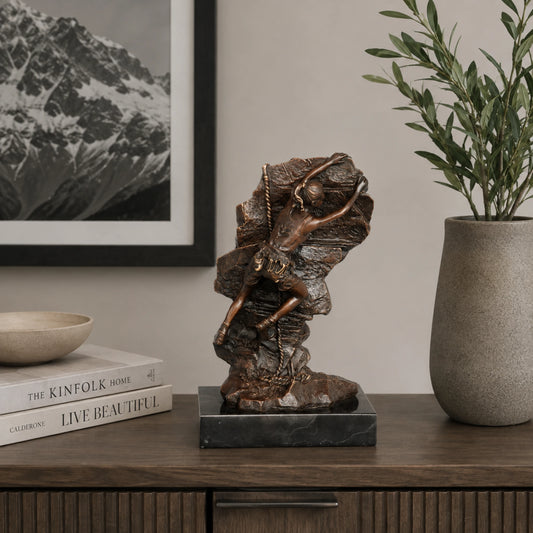 Alt:
Female rock climber bronze statue displayed as inspirational fitness decor in a modern home gym.