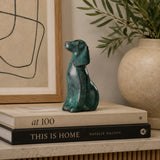 Green patina bronze seated dog sculpture displayed as modern shelf and home decor